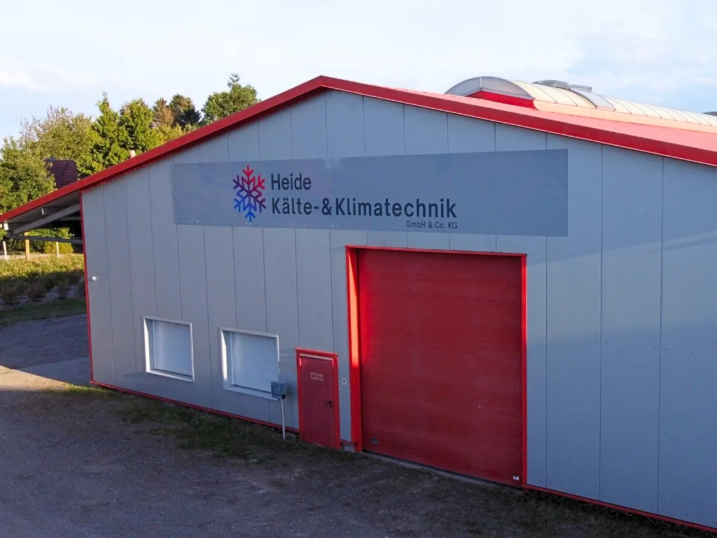 Silbergraue Halle mit roten Toren und dem Schild Heide Kälte- und Klimatechnik in Gerdau