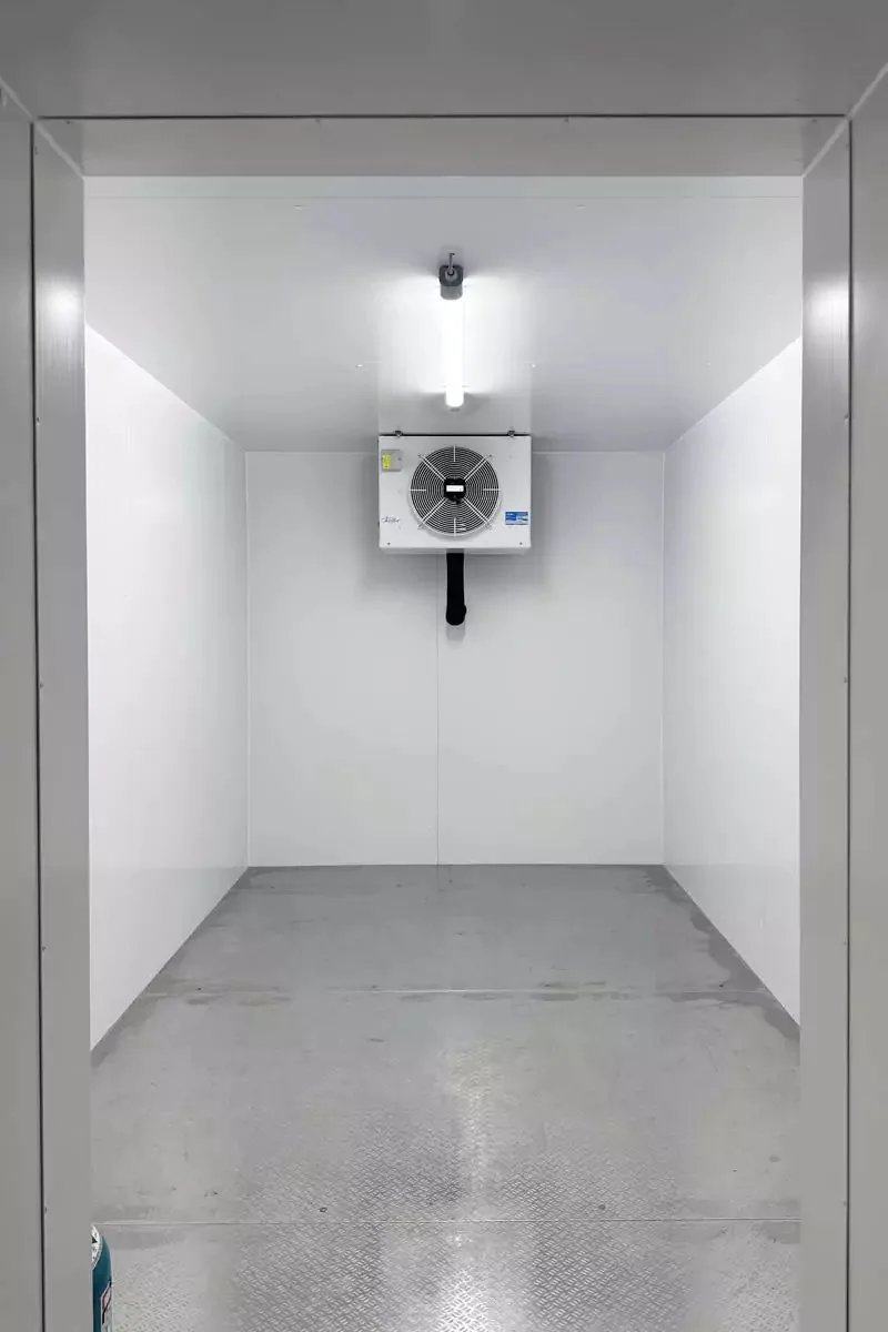 Sanierter Kühlraum mit weißen Paneelen und Verdampfer an der Rückwand