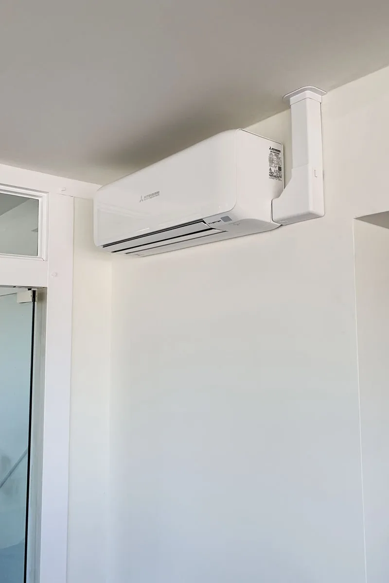 Weißes Wandgerät einer Klimaanlage in einem hellen Wohnraum