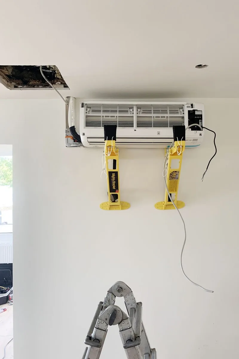 Wandgerät einer Klimaanlage bei der Montage auf gelben Montagehaltern